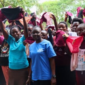 Mitarbeiterin von Go Fishnet übergibt wiederverwendbare Binden