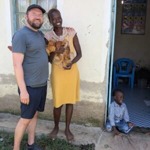 Till von Fishnet für Kinder in Afrika mit Mutter und Kind die sich über zwei Hühner freuen